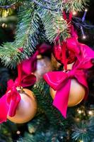 weihnachts- und neujahrsferien hintergrund. weihnachtsbaum geschmückt mit roten schleifen und kugeln. feierkonzept foto