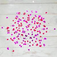 Weißer Holzhintergrund mit roten und lila Herzen Konfetti zum Valentinstag. selektiver Fokus. festliches und feiertagskonzept. foto