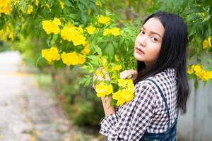 Portrait junges Mädchen mit gelben Blüten, Asiatin. foto