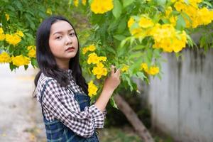 Portrait junges Mädchen mit gelben Blüten, Asiatin. foto