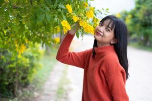 Portrait junges Mädchen mit gelben Blüten, Asiatin. foto