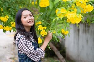 Portrait junges Mädchen mit gelben Blüten, Asiatin. foto