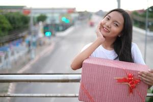 glückliches junges Mädchen mit Geschenkbox. foto