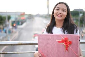 glückliches junges Mädchen mit Geschenkbox. foto