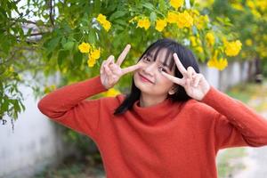 Portrait junges Mädchen mit gelben Blüten, Asiatin. foto