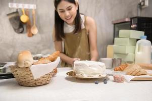 junge schöne frau backt in ihrem küchen-, bäckerei- und cafégeschäft foto