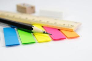 Nahaufnahme eines Bleistifts mit Papierfarbnotiz auf weißem Hintergrund foto