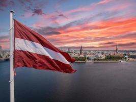 lettische Flagge mit dem Dom und einer Altstadt im Hintergrund foto