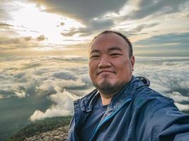 asiatische reisende machen ein selfie mit wunderschönem sonnenaufgangshimmel auf dem berg foto