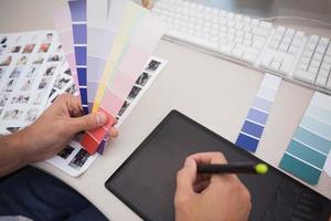 Designer mit Grafiktablett und Farbkarten
