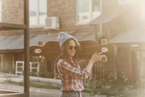 junge Frau mit seinem Longboard foto