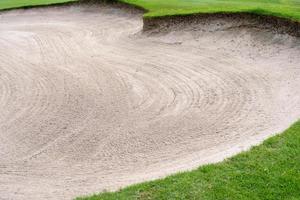 Sandkasten-Bunker-Schönheitshintergrund wird als Hindernis für Golfturniere für Schwierigkeit verwendet. und schmücken das feld für schönheit. grünes gras mit sandstruktur. foto