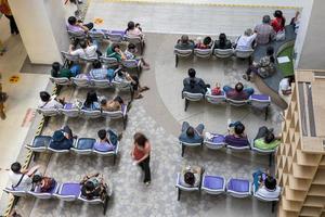 ein blick von oben, viele menschen sitzen und schlafen und warten auf medikamente. foto