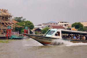 Thailand, Bangkok, Leute, die auf einem Boot auf dem Kanal segeln foto