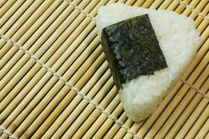 das japanische essen onigiri weißer reis in dreieckigen oder zylindrischen formen geformt und oft in nori gewickelt. foto