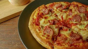 pizza in schwarzer platte auf holztisch für lebensmittelinhalt. foto