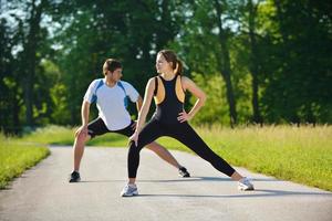 Paar beim Dehnübungen nach dem Joggen foto