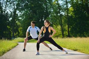 Paar beim Dehnübungen nach dem Joggen foto