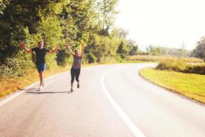 junges Paar Joggen entlang einer Landstraße foto