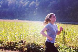 Frau, die entlang einer Landstraße joggt foto