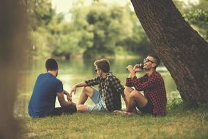 Männer sitzen am Ufer des Flusses foto