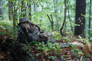 soldat in aktion, der auf waffenlaservisieroptik abzielt foto