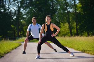 Paar beim Dehnübungen nach dem Joggen foto