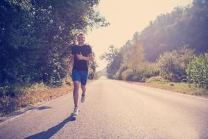 Mann joggt auf einer Landstraße foto