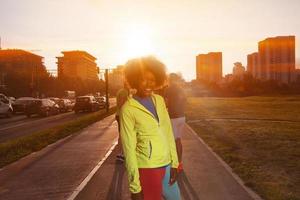 Porträt einer sportlichen jungen afroamerikanischen Frau, die im Freien läuft foto