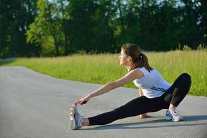 frau, die sich vor fitness ausdehnt foto