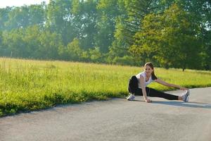 frau, die sich vor fitness ausdehnt foto