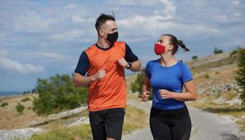 paar, das in der natur mit maske läuft foto