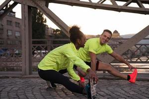 joggendes paar, das sich in der stadt aufwärmt und dehnt foto