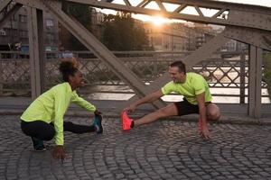 joggendes paar, das sich in der stadt aufwärmt und dehnt foto