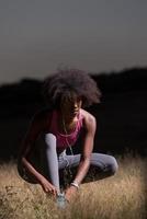 Schwarze Läuferin, die Schnürsenkel anzieht foto