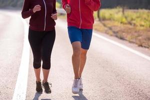 junges Paar Joggen entlang einer Landstraße foto