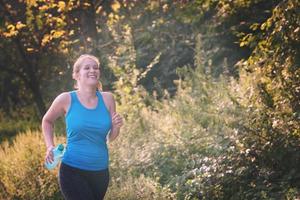 Frau, die entlang einer Landstraße joggt foto