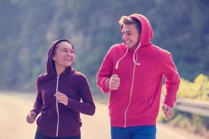 junges Paar Joggen entlang einer Landstraße foto