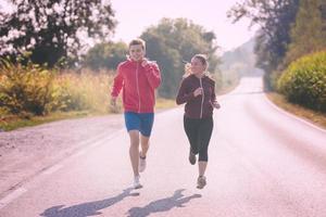 junges Paar Joggen entlang einer Landstraße foto