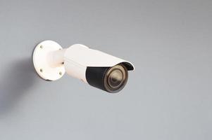 ip cctv white camera install by haben eine wasserdichte abdeckung zum schutz der kamera mit dem konzept des haussicherheitssystems. an einer grauen Wand. foto