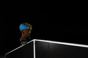 Freestyle-Snowboarder springen nachts in die Luft foto