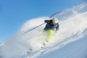 Skifahren auf Neuschnee in der Wintersaison am schönen sonnigen Tag foto