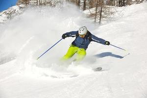 Skifahren auf Neuschnee in der Wintersaison am schönen sonnigen Tag foto