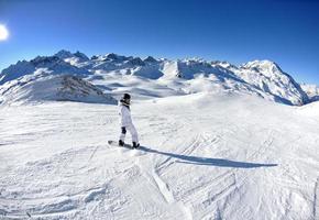 Skifahren auf Neuschnee in der Wintersaison am schönen sonnigen Tag foto