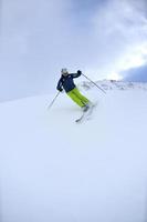 Skifahren auf Neuschnee in der Wintersaison am schönen sonnigen Tag foto