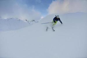 Skifahren auf Neuschnee in der Wintersaison am schönen sonnigen Tag foto