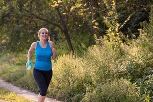 Frau, die entlang einer Landstraße joggt foto