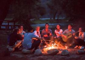 junge freunde, die sich am lagerfeuer entspannen foto