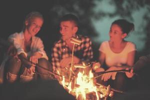 junge freunde, die sich am lagerfeuer entspannen foto