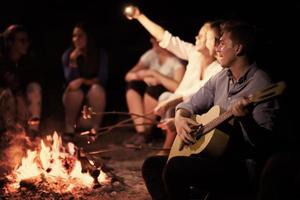 junge freunde, die sich am lagerfeuer entspannen foto